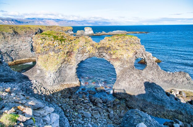 写真 空に照らされた海岸の岩層