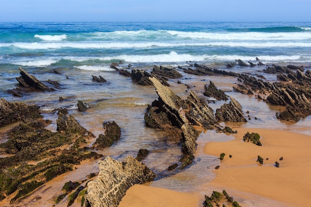 Rock formations on sandy beach (Algarve, Costa Vicentina, Portugal).