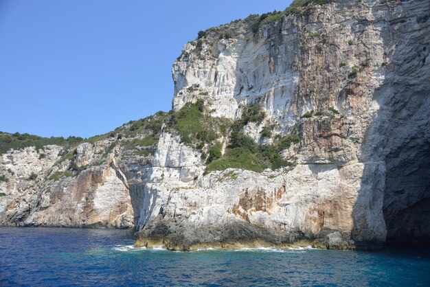 Rock formations in sea against clear sky