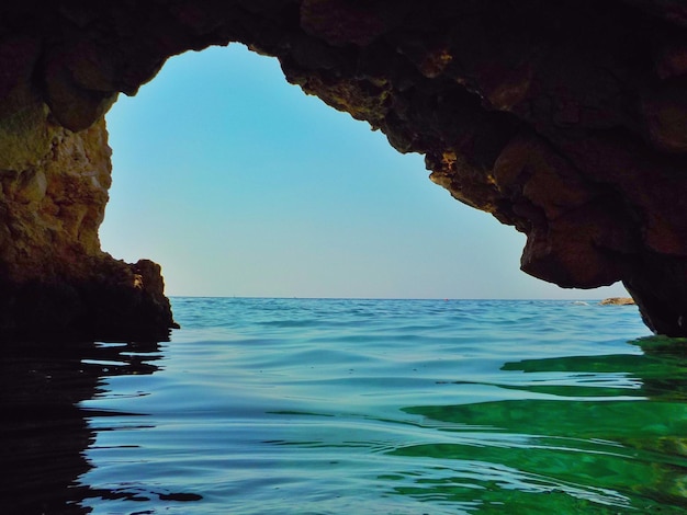 Rock formations in sea against sky