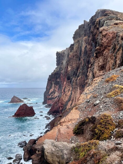 Rock formations on sea shore against sky