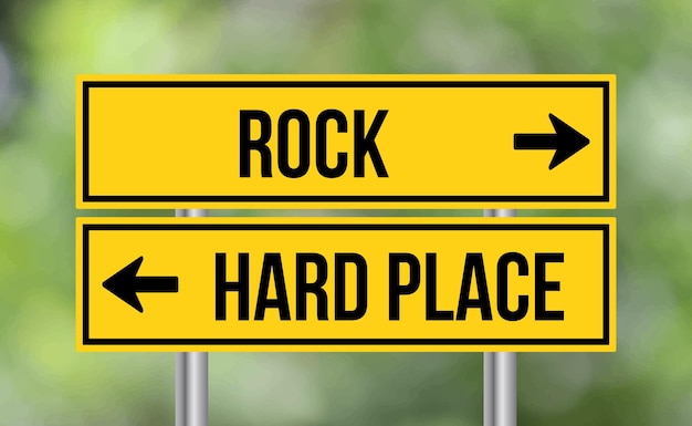 Photo rock or hard place road sign on blur background