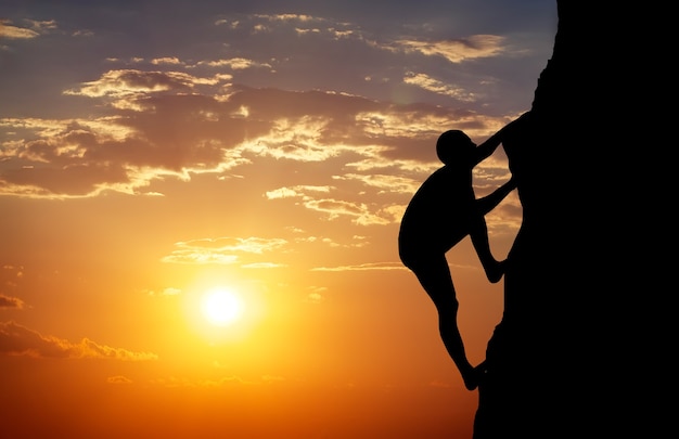 Rock klimmer bij zonsondergang achtergrond. Sport en actief leven