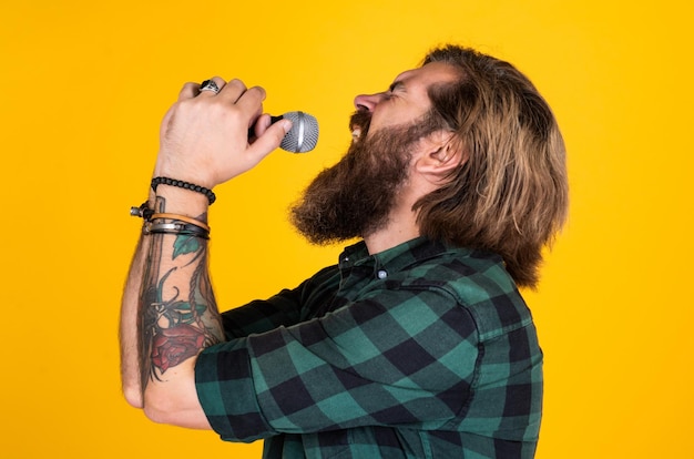 Rock music festival vocal school brutal and rock bearded man wear checkered shirt singing song male singer with mic concept of karaoke man singer love music brutal man sing with microphone