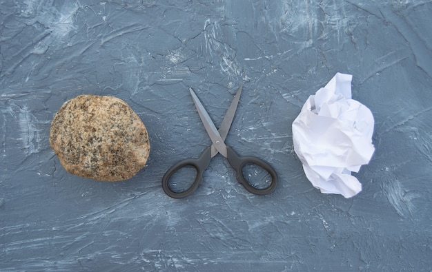 Rock scissors and paper on a gray background Attributes of a childs game