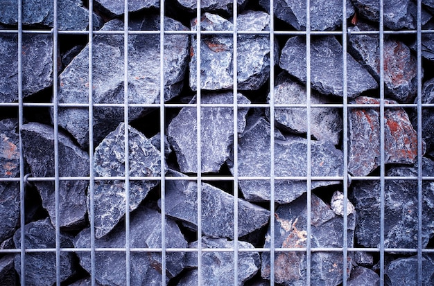 Rock stones behind steel grid fence texture background hd