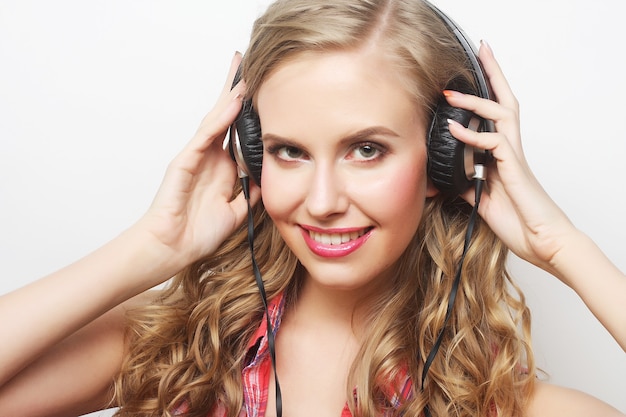 Rock style woman with headphones listening to music