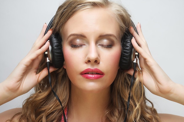 Rock style woman with headphones listening to music