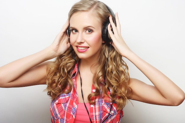 Rock style woman with headphones listening to music