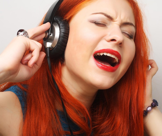 Rock style woman with headphones listening to music