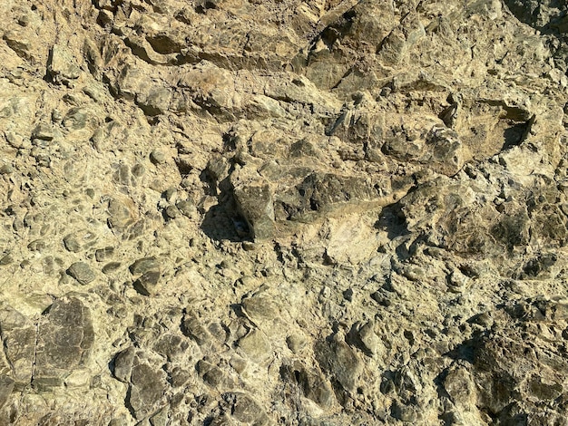 Rock texture Stone background Old weathered crumbling mountain surface in cracks