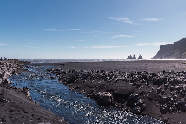 Rock troll's vingers in de oceaan nabij het strand met zwart zand in het zuiden van ijsland