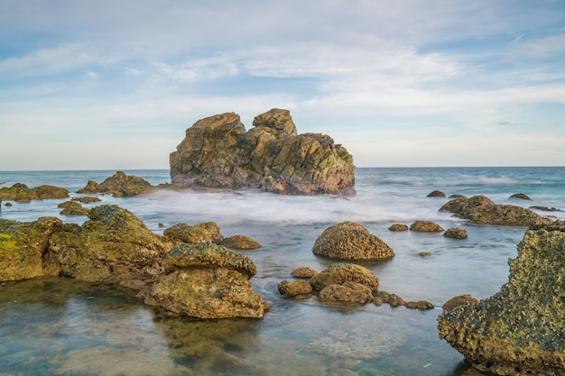 A rock in the water with the word sea on it