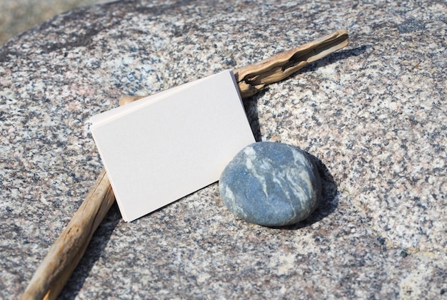 A rock and a white card on a rock with a small white card next to it.