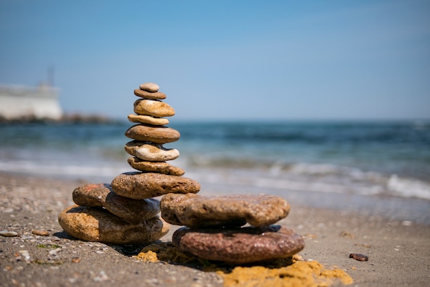 Rock zen piramide van kleurrijke kiezels op een zandstrand op de achtergrond van de zee