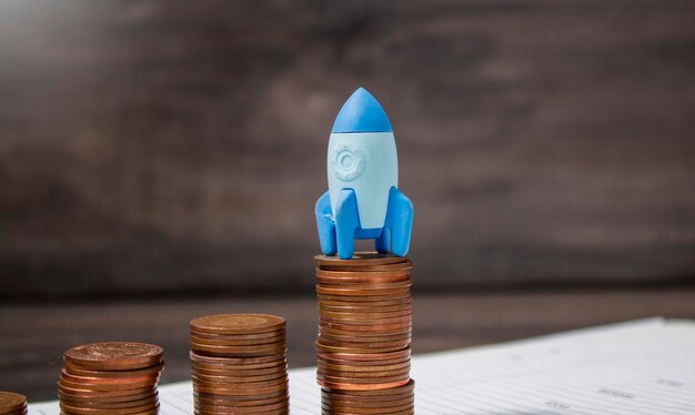 Rocket on growing coins on papers