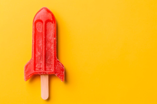 Photo rocket shaped summer ice lolly on a bright yellow background