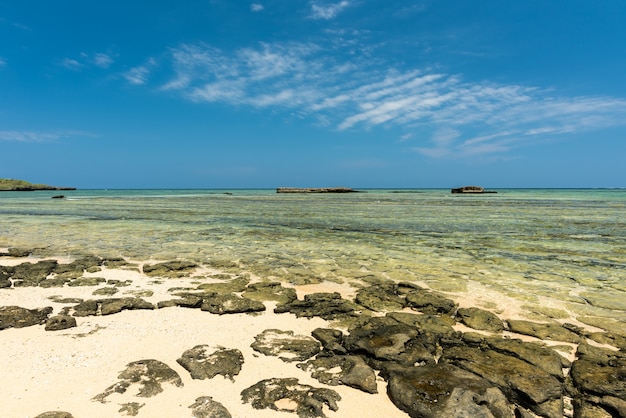 Rocks appearing on the beach sand at low tide blue sky  Iriomote Island