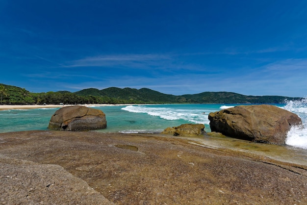 Rocks on beach against blue sky