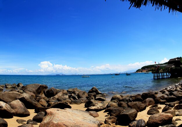 Rocks on beach against blue sky