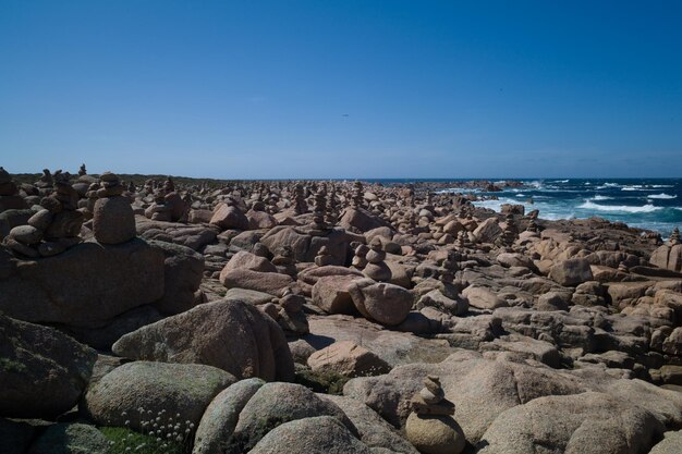 Rocks on beach against clear blue sky