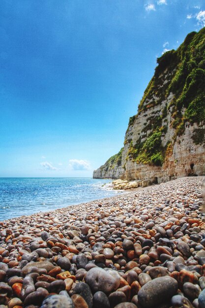 Rocks on beach against clear sky