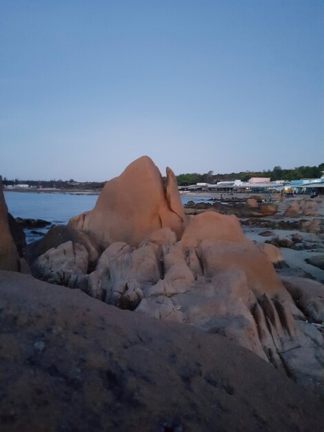 Rocks on beach against clear sky