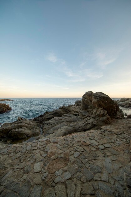 Rocks on beach against sky during sunset