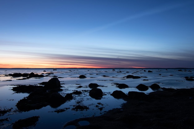 Photo rocks on beach against sky during sunset