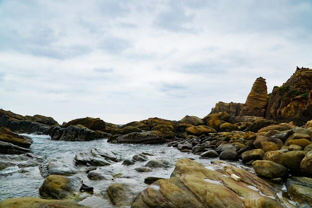rocks at beach against sky