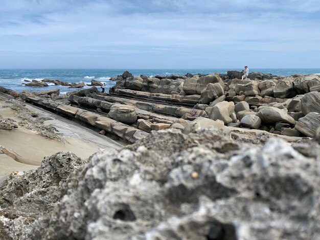 Rocks on beach against sky