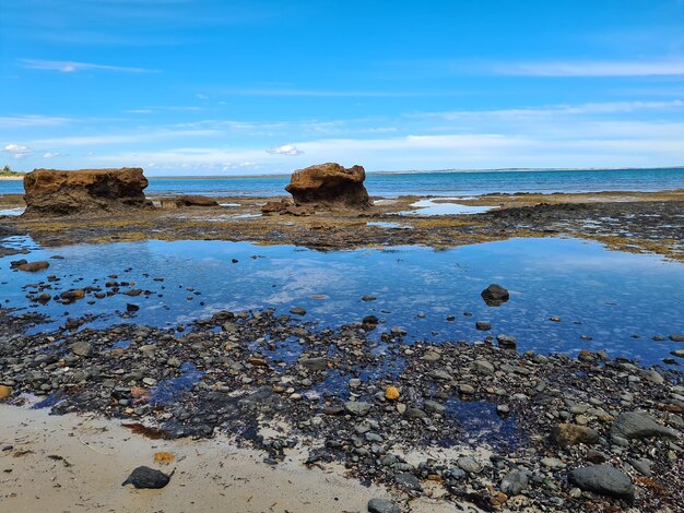 Rocks on beach against sky