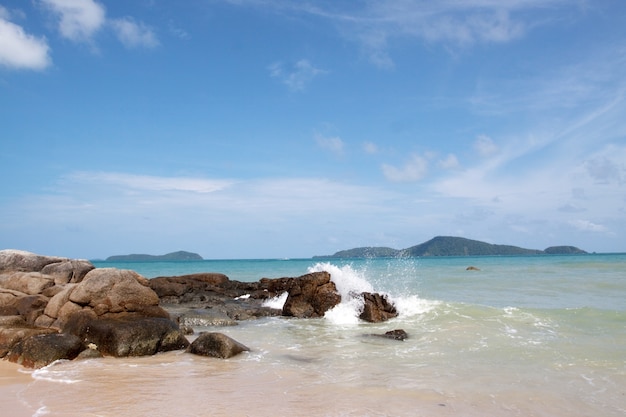 Rocks on the beach of the bright blue sea.