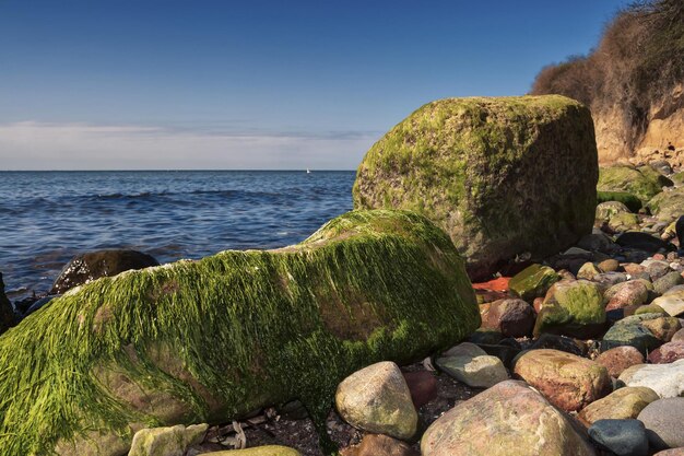 Rocks by sea against sky