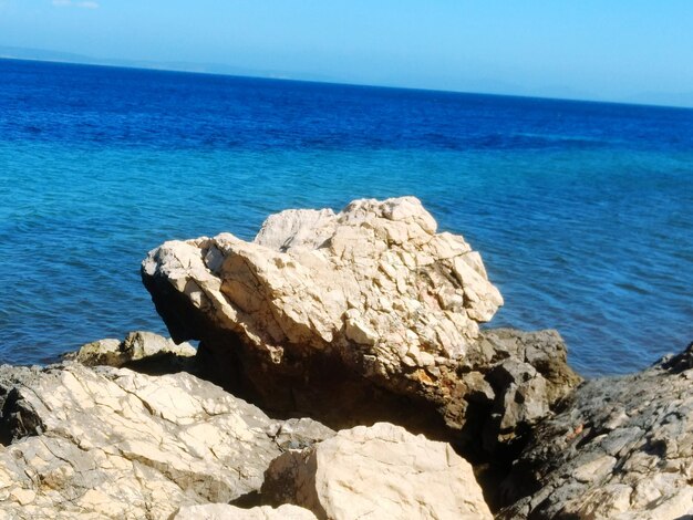 Rocks by sea against sky