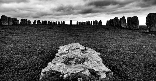 Photo rocks on field against cloudy sky