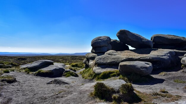 Rocks on land against clear blue sky