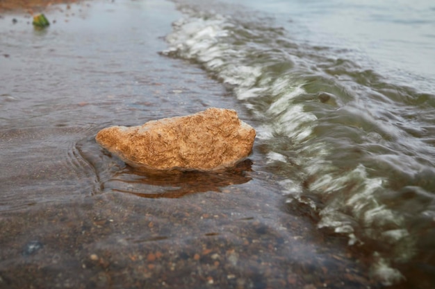 rocks on the river beach with wave motion blur, selective focus