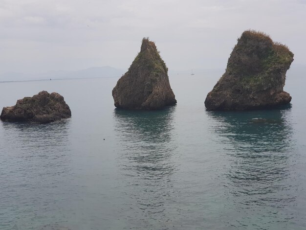 Rocks in sea against sky