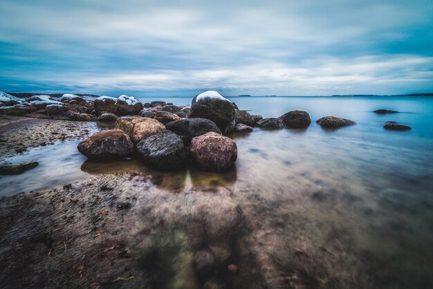 Rocks in sea against sky