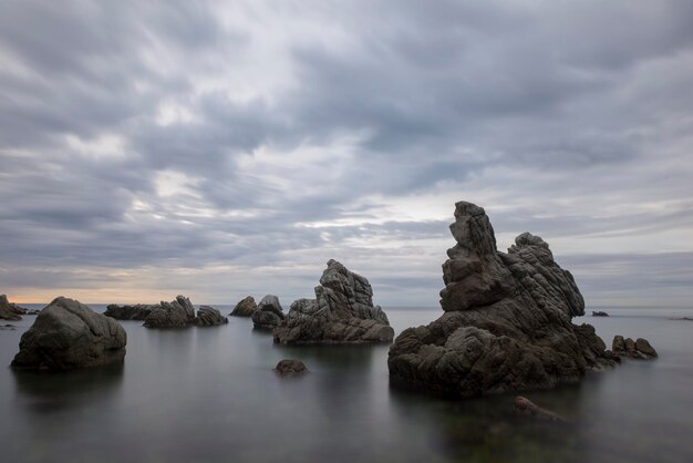 Rocks in sea against sky