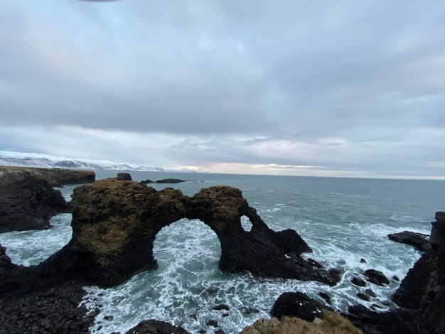 Rocks on sea shore against sky