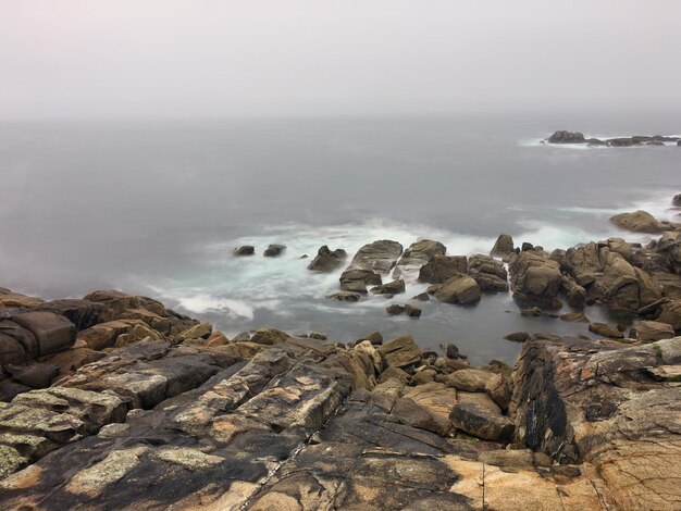 Photo rocks on sea shore against sky