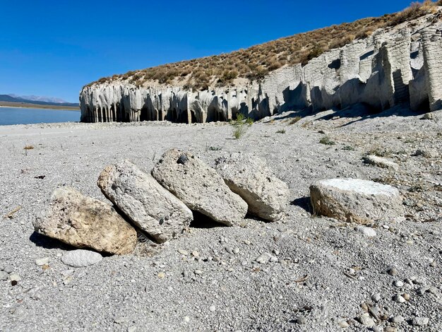 Rocks on shore against clear blue sky