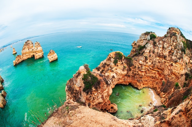 Rocks on the shore of Atlantic ocean in Algarve, Portugal. Beautiful summer landscape. Fish eye lens effect