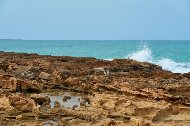 熱帯の砂浜の岩と波