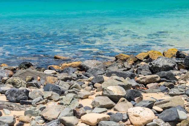 Rocky beach and a calm turquoise sea on a beach in Sint Marteen