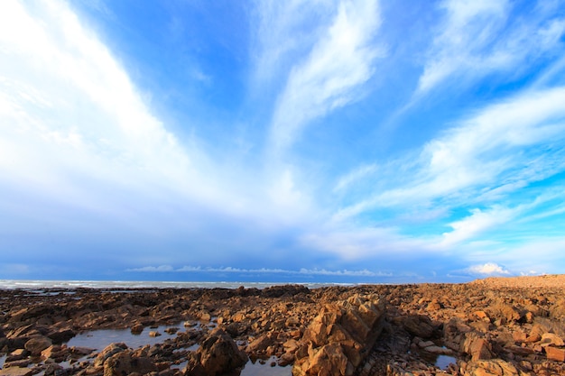 Photo rocky beach. sky withe clouds