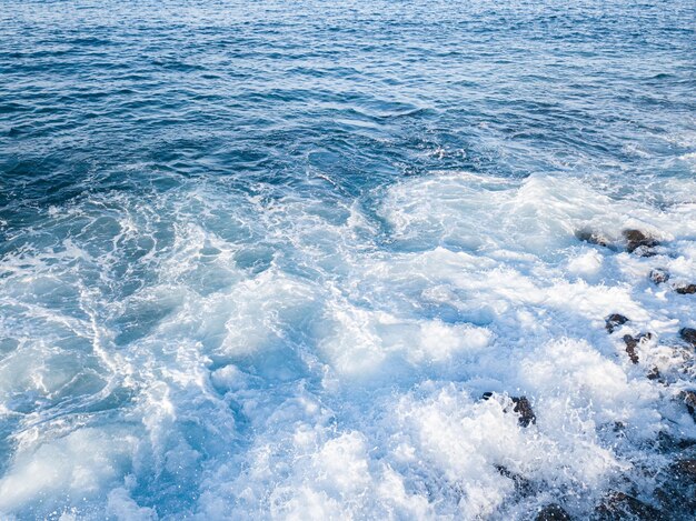 Rocky beach with Atlantic Ocean waves meeting with underwater sharp rocks Blue sea