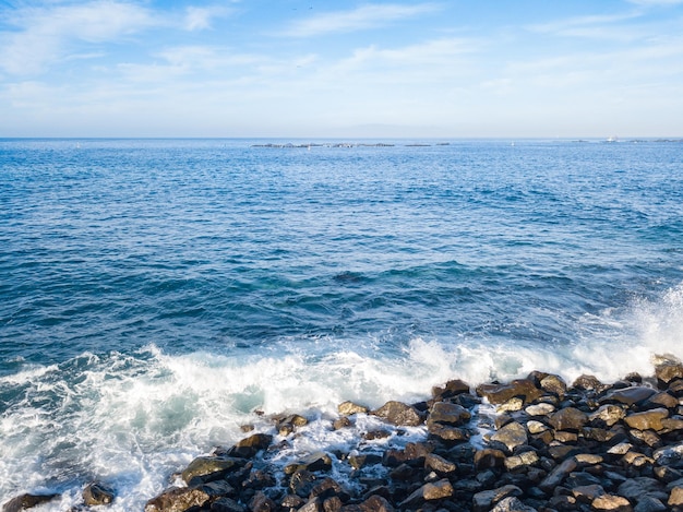 アトランティック海の波が水中のい岩と出会う岩のビーチ